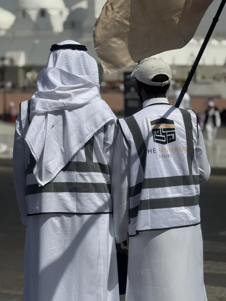 Two Muhrim guides in branded white vests